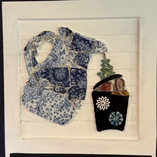 Mosaic collage of a blue and white patterned elephant formed from broken ceramic tiles, with a black tote holding a small plant at its trunk.
