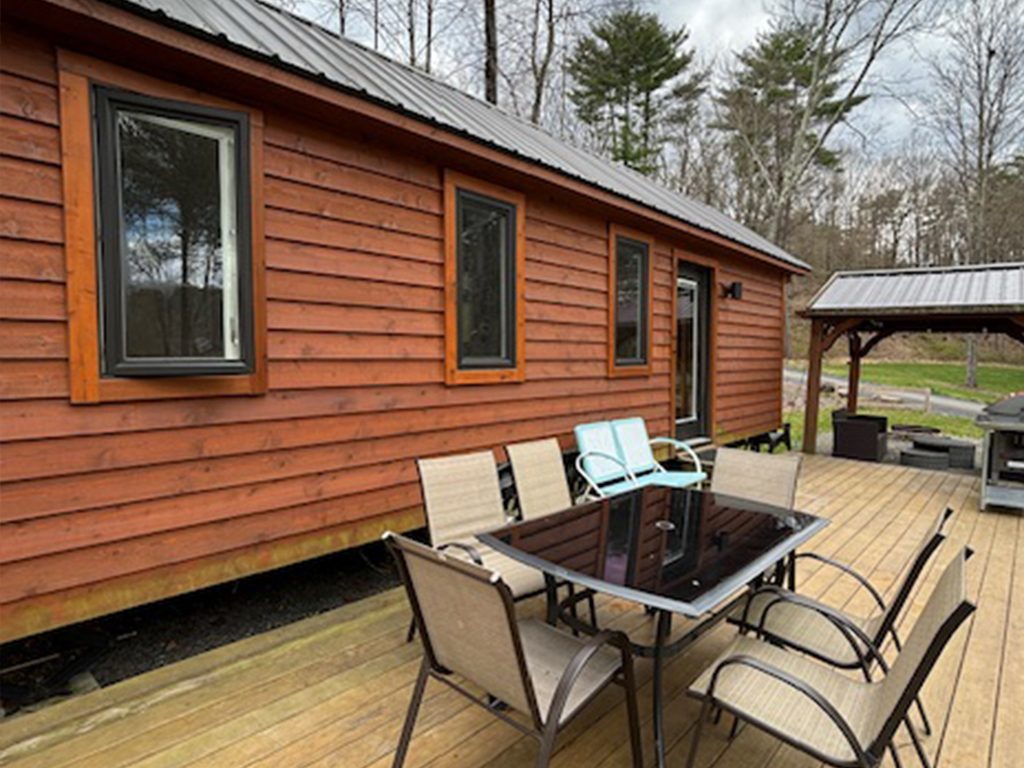Exterior view of the lodge, tables with 6 chairs and gazebo